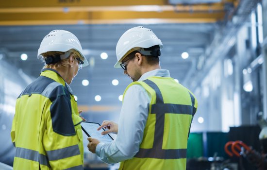 Deux ingénieurs discutant autour dune tablette pour symboliser l'excellence industrielle.